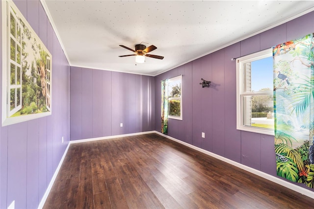 unfurnished room featuring ornamental molding, hardwood / wood-style flooring, wooden walls, and ceiling fan