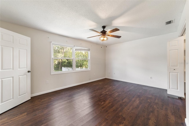 empty room featuring a textured ceiling, dark wood-type flooring, and ceiling fan