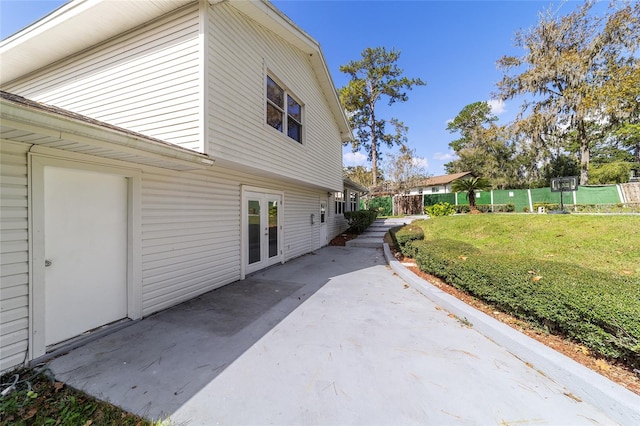 view of side of property with a patio area and a lawn