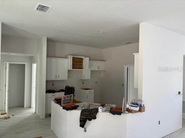 kitchen featuring light wood-type flooring and white cabinets