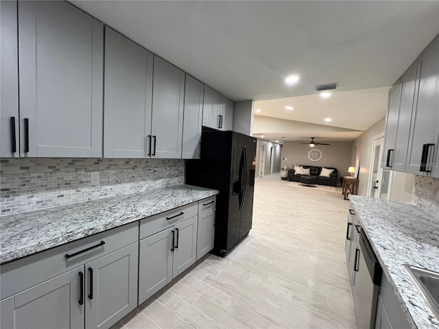 kitchen featuring decorative backsplash, ceiling fan, gray cabinetry, and light stone countertops