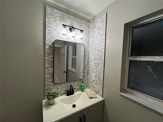 bathroom with vanity, a textured ceiling, and backsplash