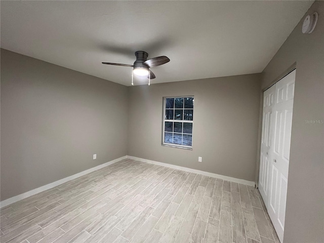 unfurnished bedroom featuring ceiling fan, light wood-type flooring, and a closet