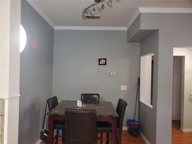 dining area with hardwood / wood-style floors and ornamental molding