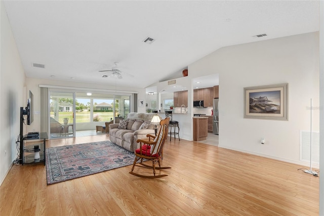 living room featuring light wood-type flooring, lofted ceiling, and ceiling fan