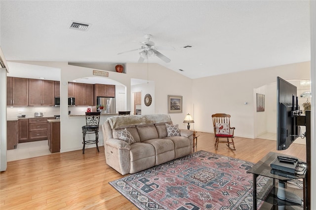 living room with light hardwood / wood-style floors, lofted ceiling, and ceiling fan