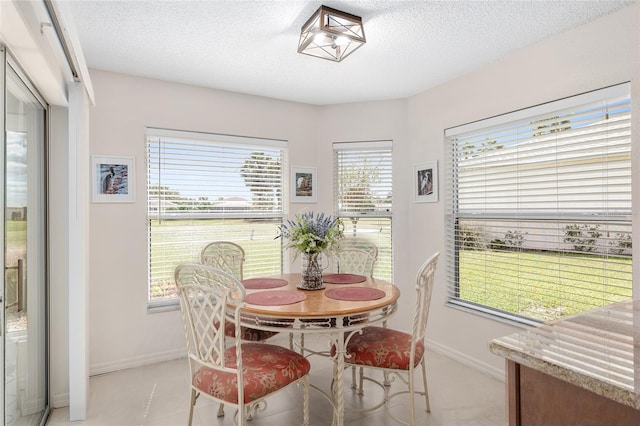 dining room featuring a textured ceiling and light tile patterned floors