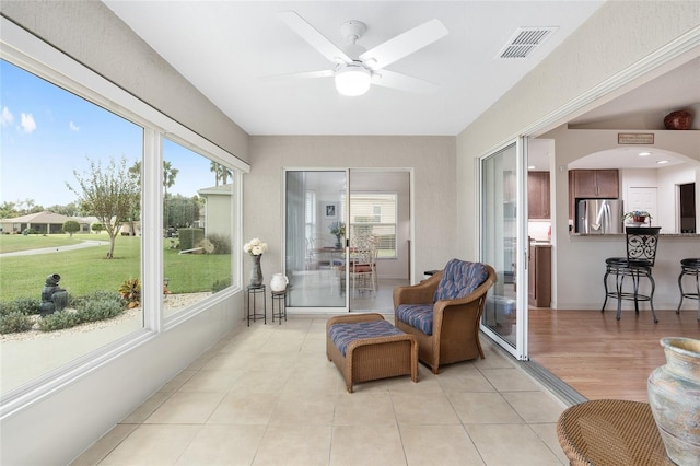 sunroom featuring ceiling fan and a healthy amount of sunlight