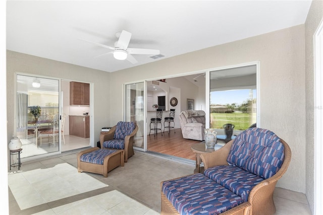 sitting room featuring ceiling fan, light hardwood / wood-style flooring, and vaulted ceiling