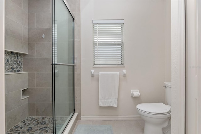 bathroom with tile patterned floors, toilet, and an enclosed shower