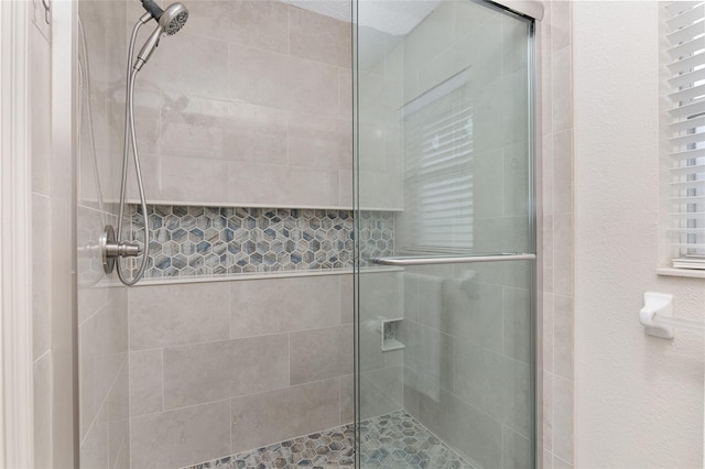 bathroom with a shower with door