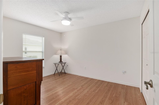 15596 SW 13th Cir, Ocala, FL 34473 - unfurnished bedroom with light wood finished floors, a textured ceiling, a closet, baseboards, and ceiling fan