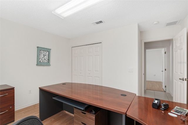 office featuring light hardwood / wood-style flooring and a textured ceiling