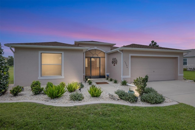 view of front of property with a garage and a yard