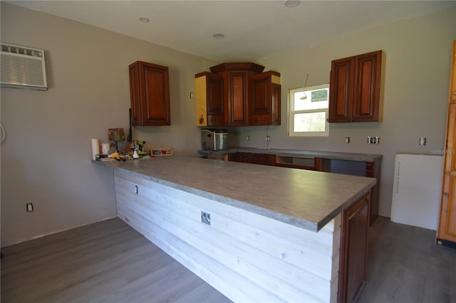 kitchen with a wall mounted AC, kitchen peninsula, dark hardwood / wood-style floors, and a breakfast bar