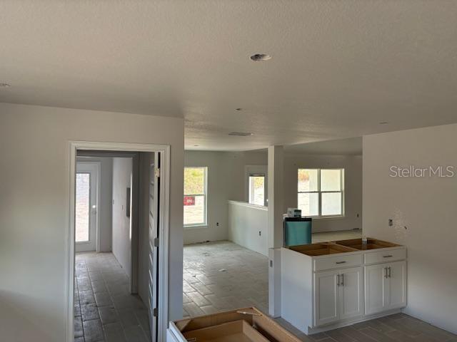 kitchen with white cabinets and a textured ceiling