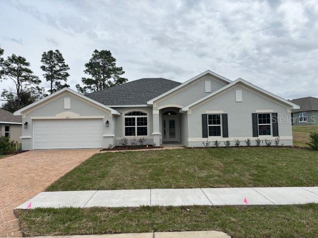 ranch-style house featuring a garage and a front lawn