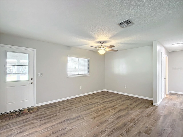 spare room with ceiling fan, hardwood / wood-style floors, and a textured ceiling