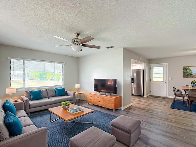 living room featuring hardwood / wood-style floors, ceiling fan, a healthy amount of sunlight, and a textured ceiling