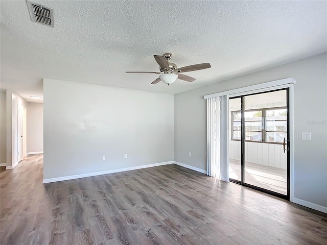 empty room featuring ceiling fan, wood-type flooring, and a textured ceiling