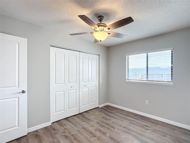 unfurnished bedroom featuring a closet, ceiling fan, and light hardwood / wood-style flooring