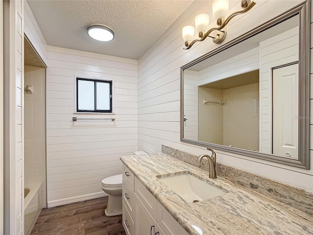 full bathroom featuring wood walls, hardwood / wood-style floors, a textured ceiling, and toilet