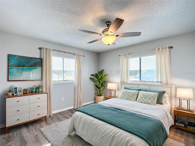 bedroom with hardwood / wood-style floors, a textured ceiling, and ceiling fan