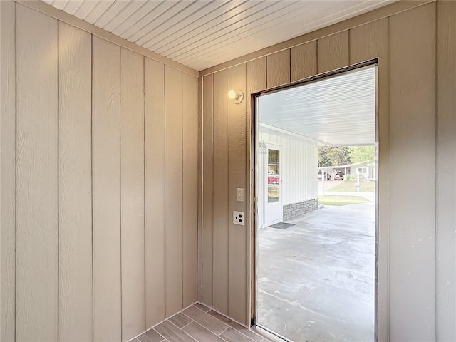 entryway with wood walls and light wood-type flooring