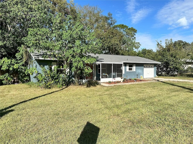 back of house featuring a garage, a sunroom, and a lawn