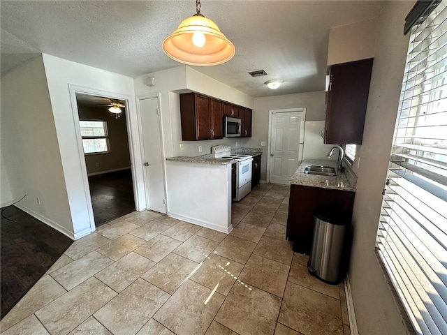 kitchen with electric stove, sink, ceiling fan, dark brown cabinets, and a textured ceiling