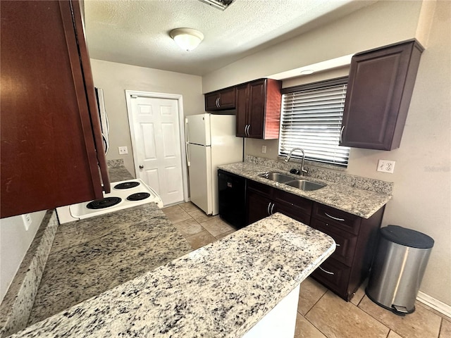 kitchen with light stone counters, white appliances, and sink