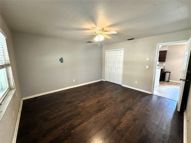 empty room with ceiling fan and dark hardwood / wood-style floors