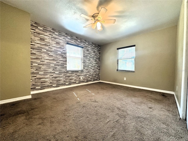 carpeted empty room featuring ceiling fan and a textured ceiling