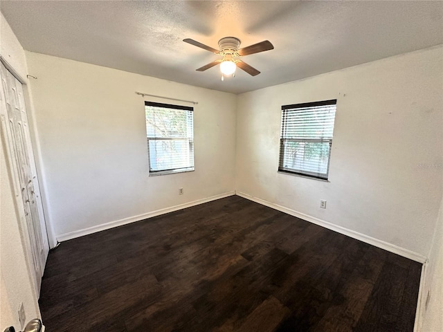 unfurnished bedroom with dark hardwood / wood-style flooring, a textured ceiling, and ceiling fan