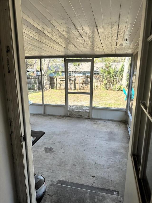 unfurnished sunroom featuring wood ceiling and a wealth of natural light