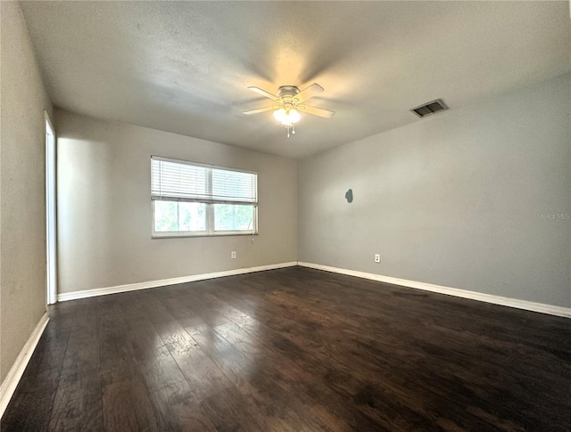 spare room with dark wood-type flooring and ceiling fan