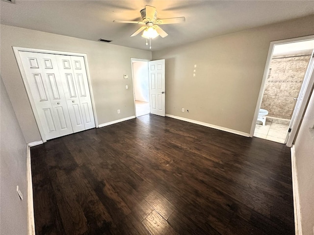 unfurnished bedroom with dark hardwood / wood-style flooring, connected bathroom, a closet, and ceiling fan