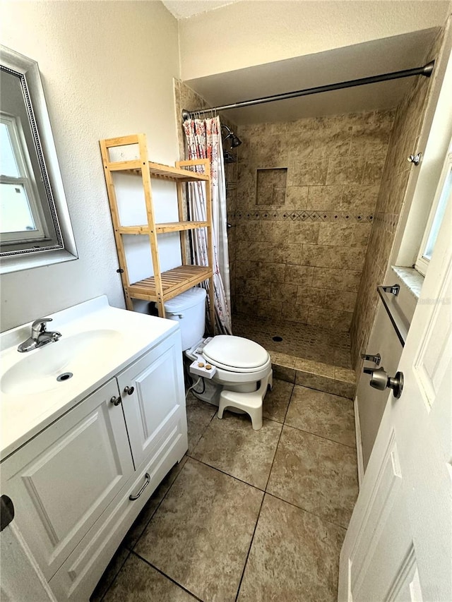 bathroom featuring toilet, vanity, tile patterned floors, and a shower with shower curtain