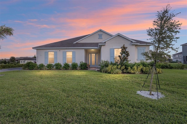 single story home featuring a lawn