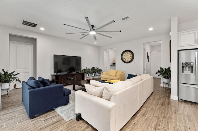 living room with light hardwood / wood-style flooring and ceiling fan