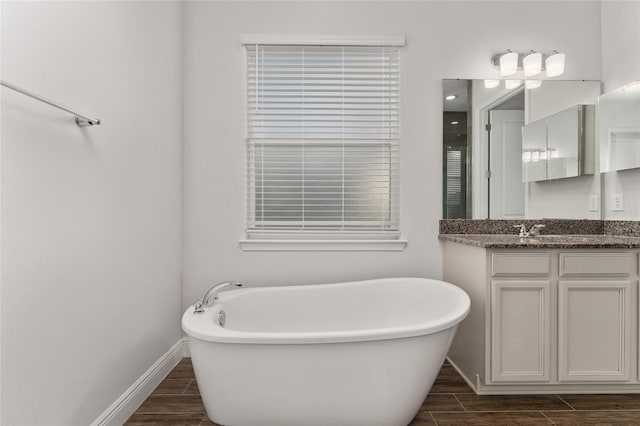 bathroom with hardwood / wood-style floors, a tub to relax in, and vanity