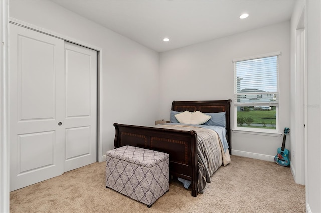 bedroom with a closet and light colored carpet