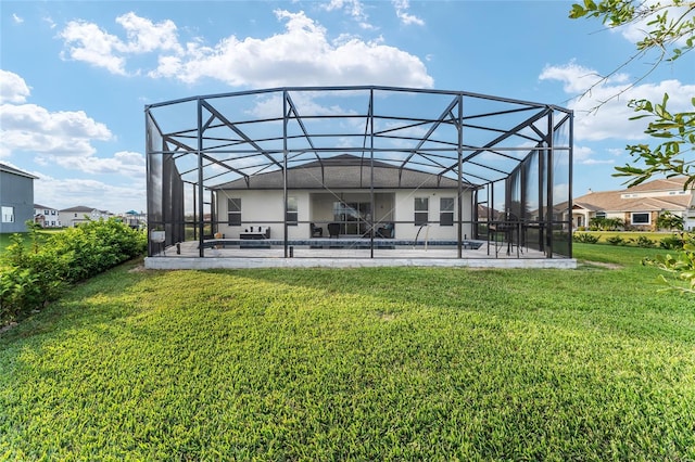 rear view of property with a patio, a lawn, a lanai, and a pool