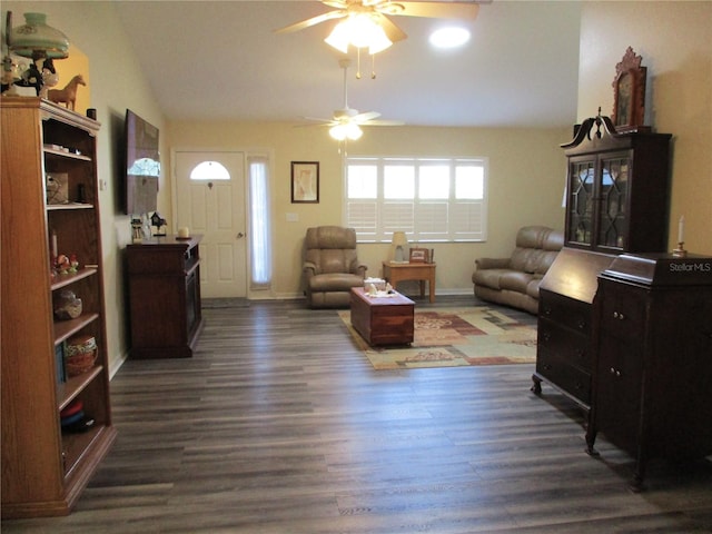 living room featuring dark hardwood / wood-style flooring, vaulted ceiling, and ceiling fan