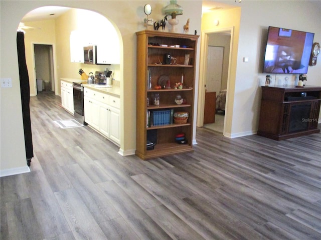 bar featuring stainless steel appliances, wood-type flooring, and white cabinetry