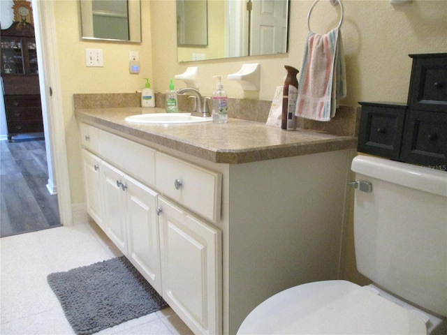 bathroom featuring tile patterned floors, vanity, and toilet