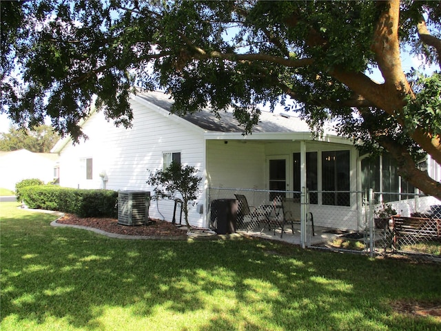 view of side of property with central AC and a yard