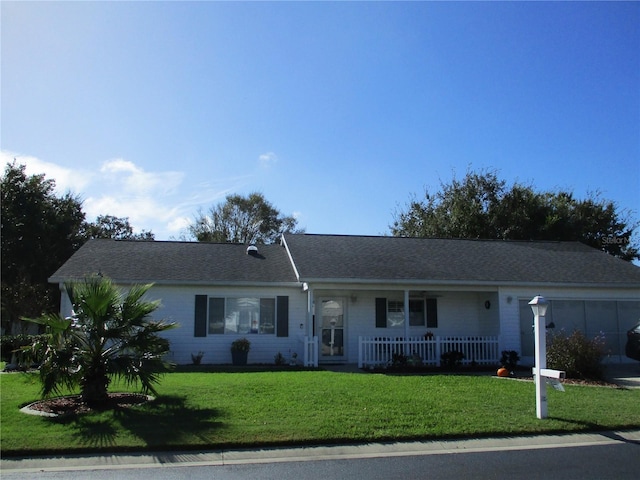 ranch-style home with a garage, a front yard, and covered porch