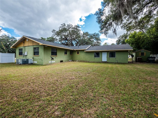 back of house with a yard and central AC unit