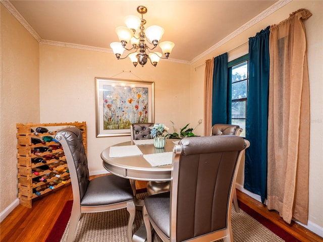 dining area with a notable chandelier, hardwood / wood-style flooring, and crown molding